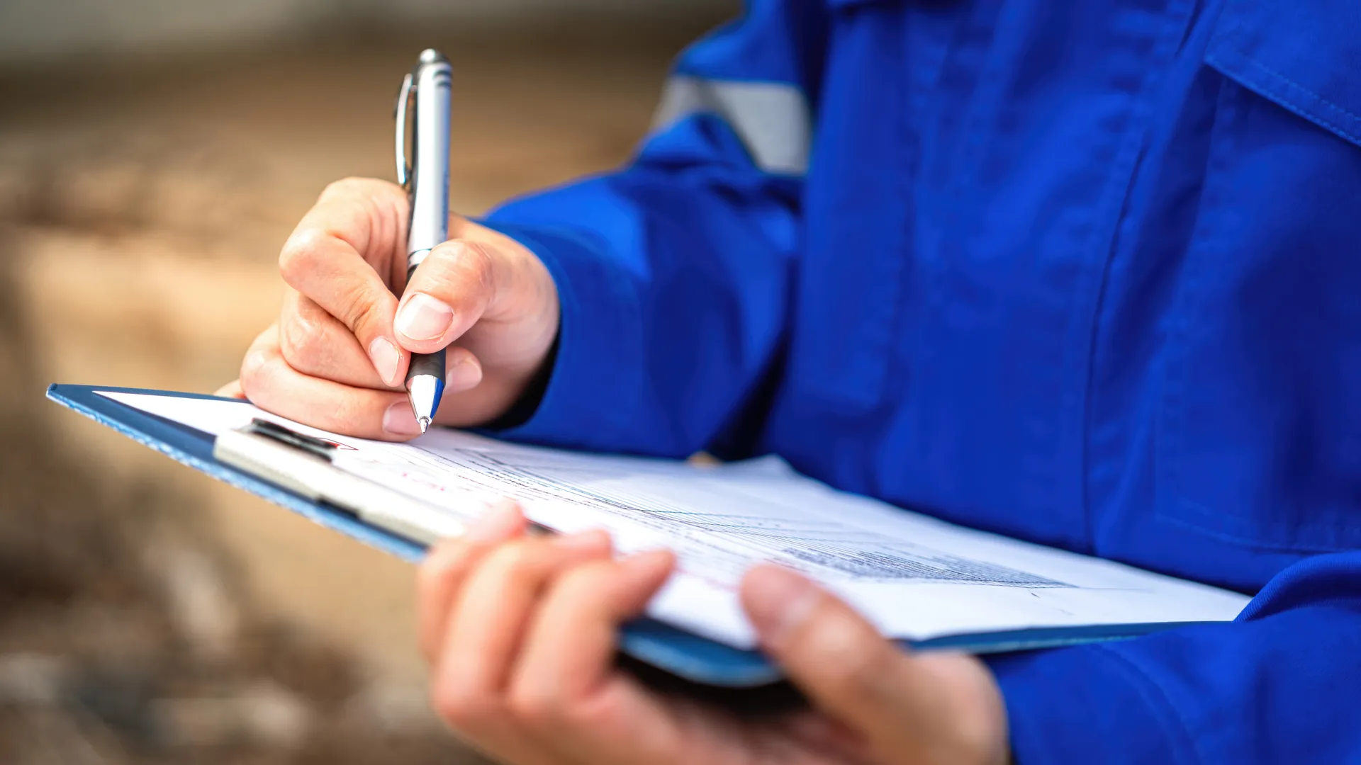 A Blouin Brothers team member performs a home inspection, holding a clipboard.