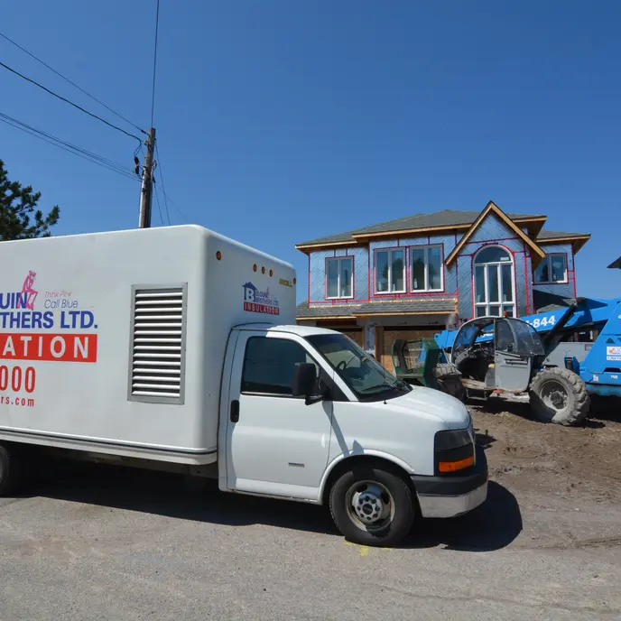 A cropped photo of a Blouin Brothers truck parked in front of a residential property.