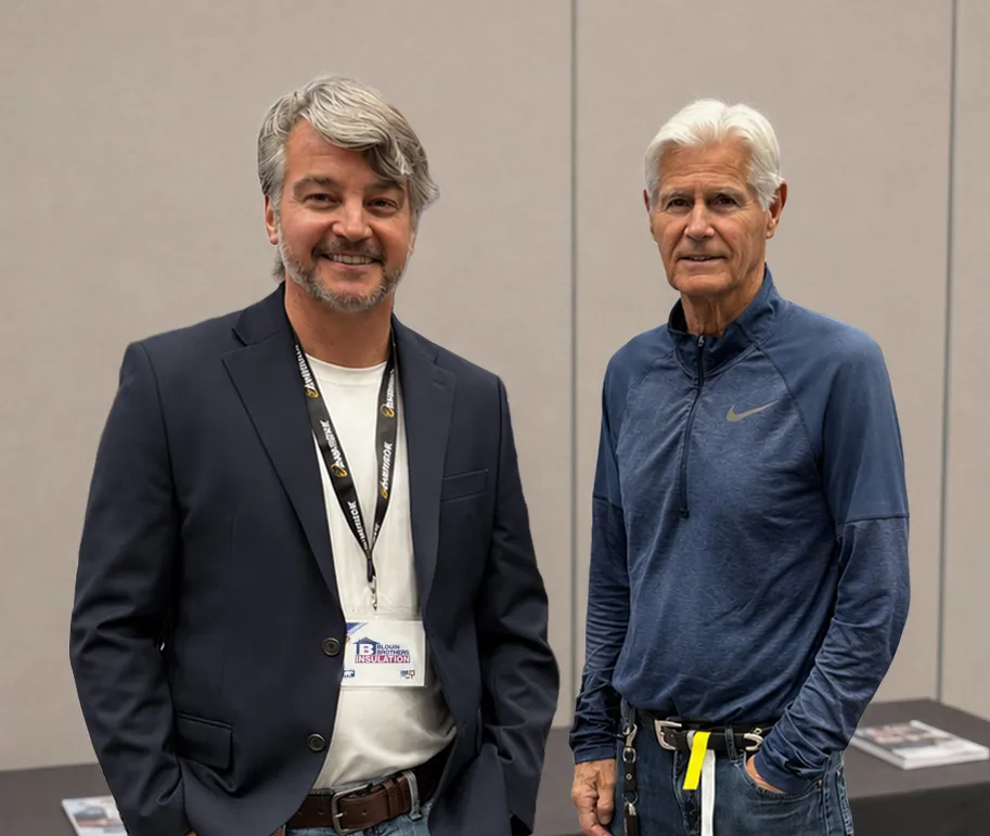 Company founder John and his brother Donald Blouin at a conference, smiling for the camera.